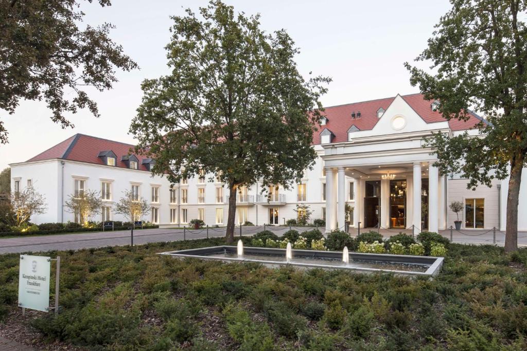 un bâtiment avec une fontaine devant lui dans l'établissement Kempinski Hotel Frankfurt Gravenbruch, à Gravenbruch