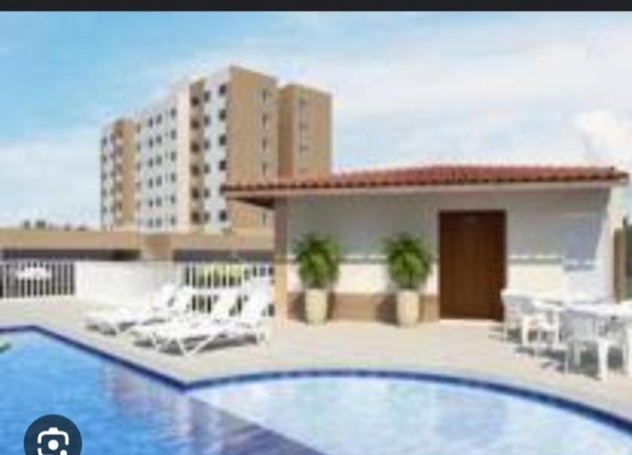 uma vista para uma piscina com um edifício em Apartamento flat em condomínio club em Aracaju