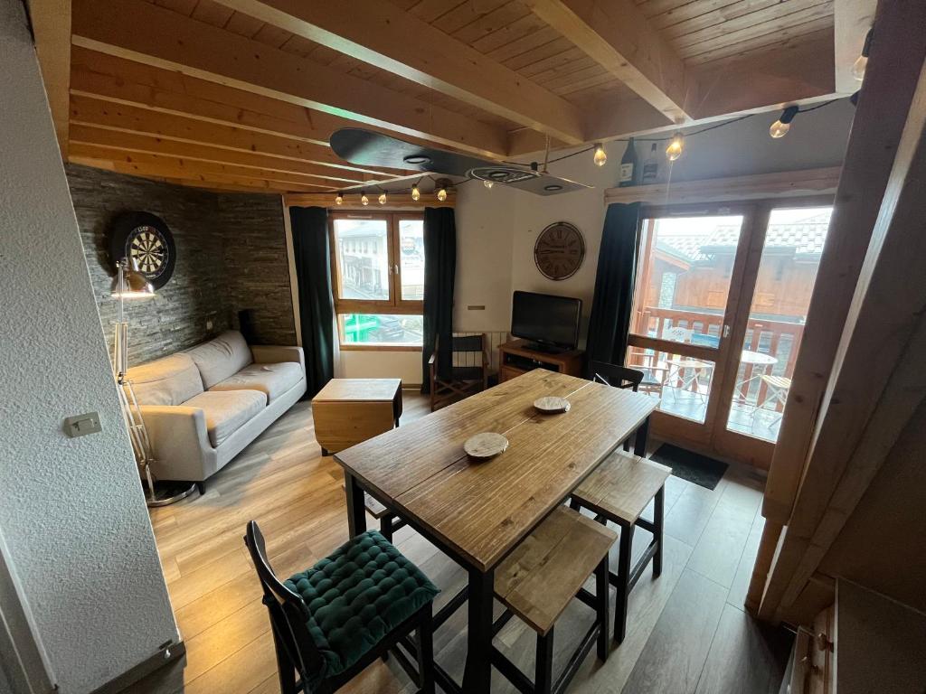 a living room with a wooden table and chairs at Appartement 6-8 personnes à 3 minutes des pistes in Peisey-Nancroix