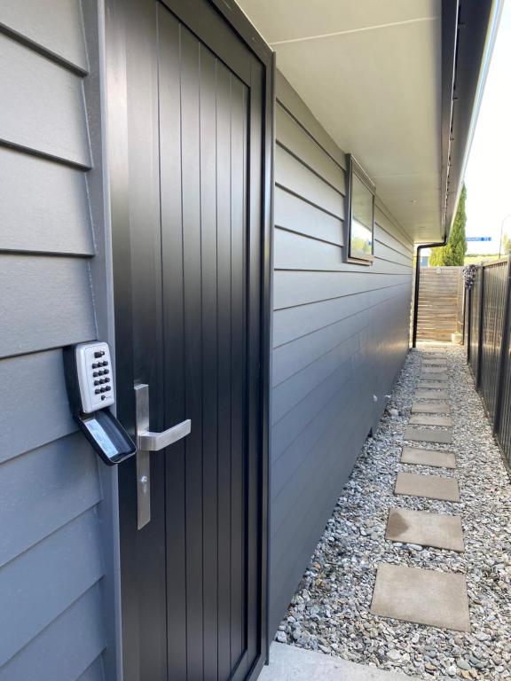 a black door to a house with a walkway at 2 Bedroom Unit in Queenstown in Frankton Wharf