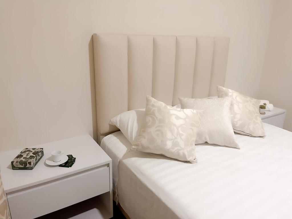 um quarto com 2 camas com almofadas brancas e uma mesa em Suite Posada Express with Free Airport Shuttle em Santa Cruz de la Sierra