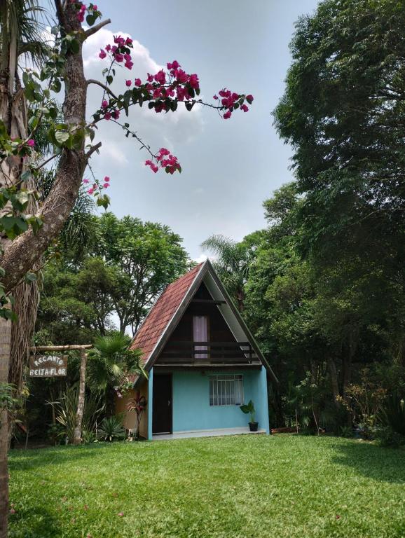 uma pequena casa num quintal com uma árvore em Pousada Recanto do Beija Flor em São José dos Pinhais