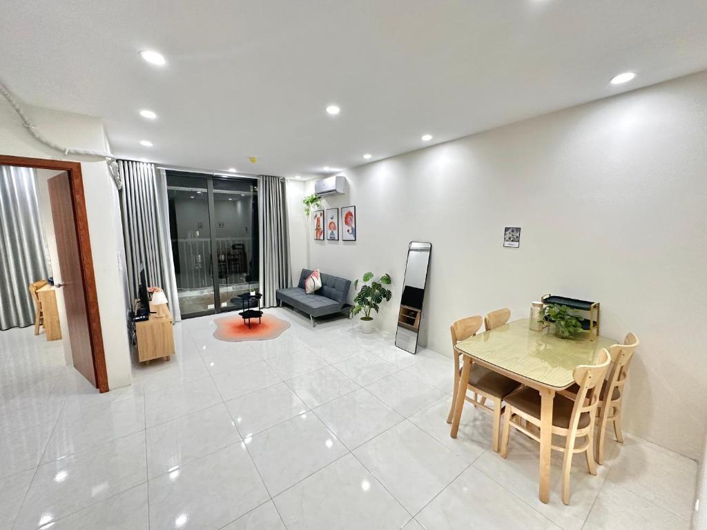 a living room with a table and a couch at Housinco Premium - Serviced Apartments Nguyễn Xiển Street near Tops Market in Hanoi