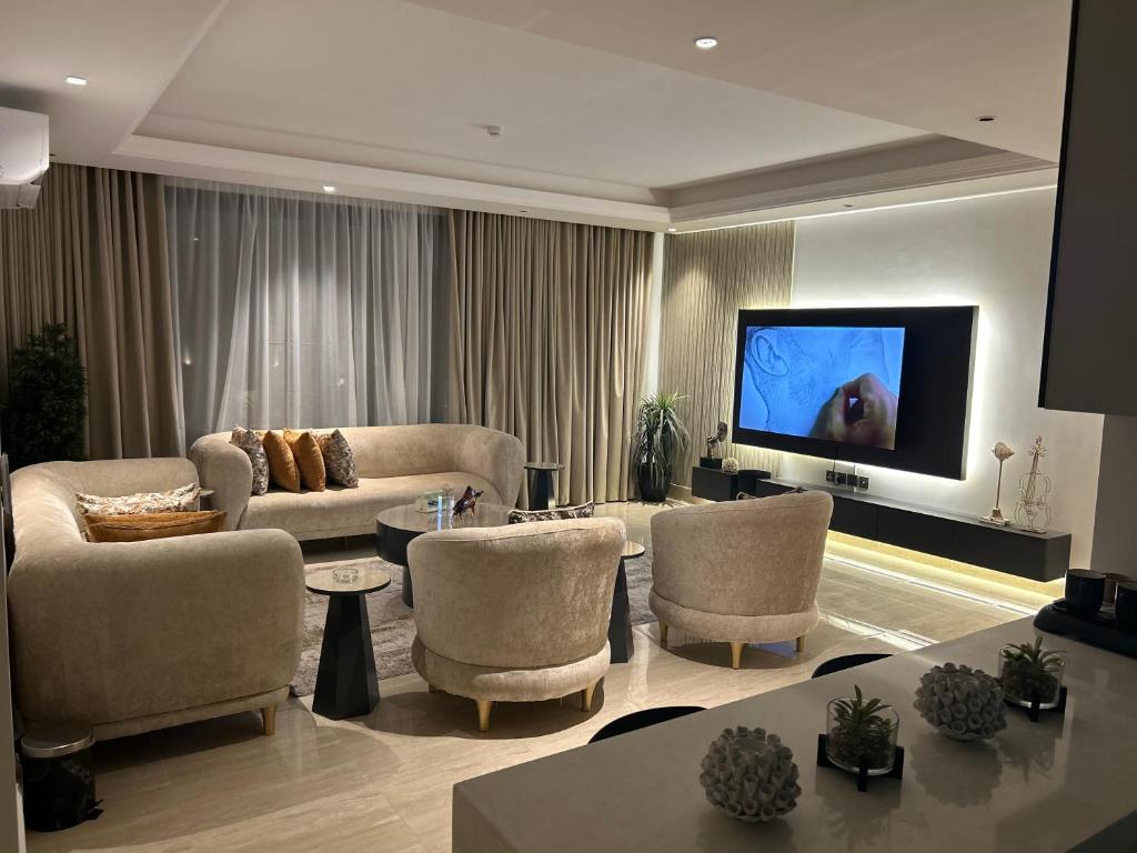 un soggiorno con divani e TV a schermo piatto di Two-Bedroom Apartment a Riyad