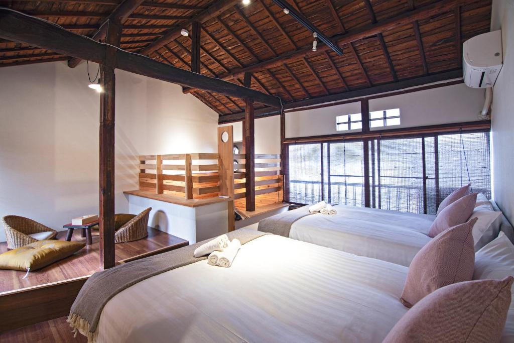 - une chambre avec 2 lits et une grande fenêtre dans l'établissement -旅time Harusora 住吉晴天- 住吉大社周辺, à Osaka
