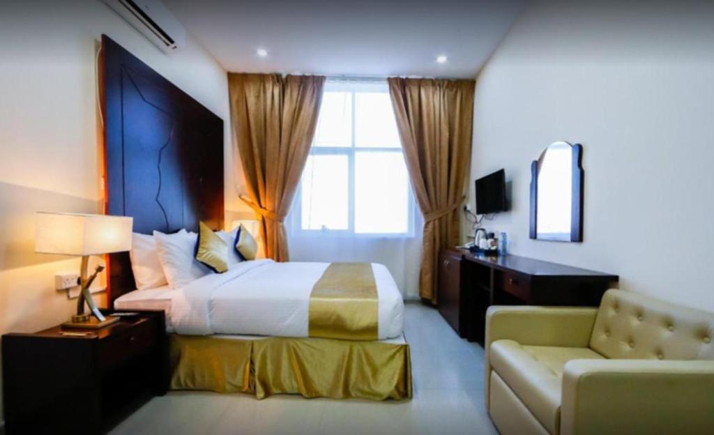 ラス・アル・ハイマにあるSH Hotel - Free Parkingのベッドとソファ付きのホテルルーム