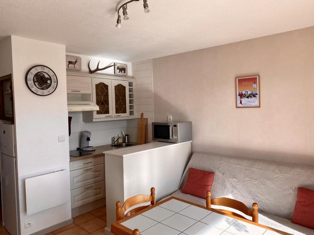 - une cuisine avec un canapé et une table dans une chambre dans l'établissement Les Angles - Appartement cosy T2 - 6 personnes avec parking et véranda - FR-1-758-15, aux Angles