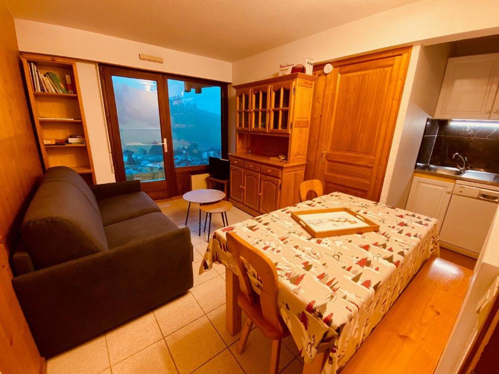 un salon avec un canapé et une table dans l'établissement Appartement cosy avec terrasse, parking et vue montagne à La Clusaz - FR-1-459-220, à La Clusaz
