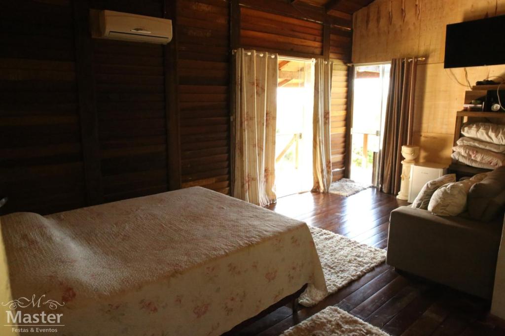 a bedroom with a bed and a couch at Pousada nascente das aguas in Paranaguá