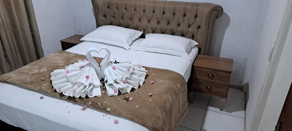 a bedroom with a bed with two towels on it at Casa de Temporada no Centro de Pedra Azul in Pedra Azul