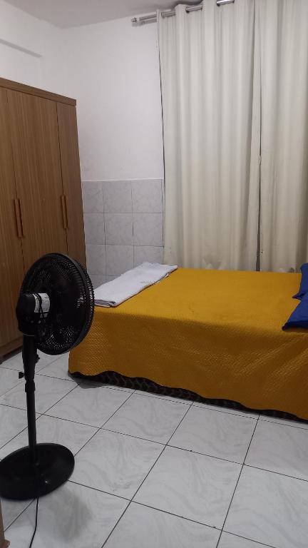 a bedroom with a bed and a fan on the floor at Apartamento 1 Quarto No Centro para até 2 pessoas in Salvador