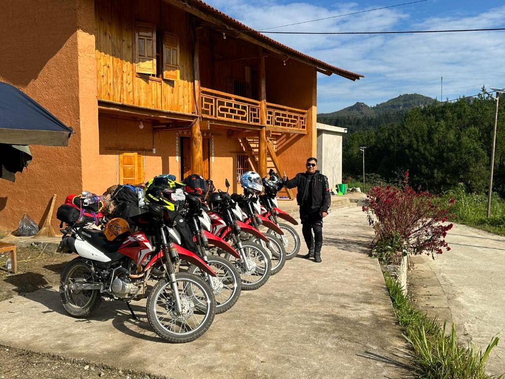 a man standing in front of a row of motorcycles at Hoàng nam Homestay in Quang Ba