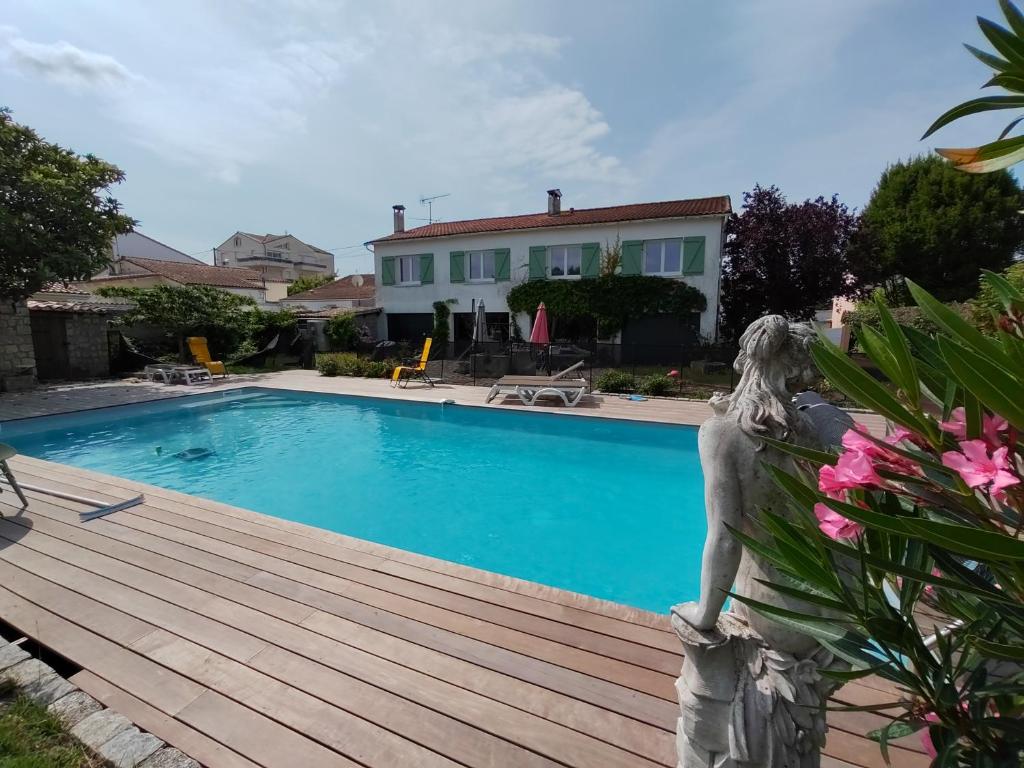 une statue assise sur une terrasse en bois près d'une piscine dans l'établissement Villa 7 chambres avec grande piscine non chauffée à 600 m de la plage, à Royan