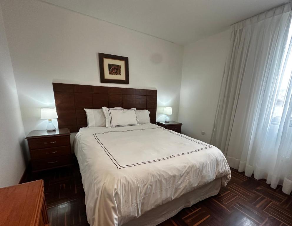 1 dormitorio con 1 cama grande con sábanas blancas y ventana en San Isidro Olivar 2 bedroom Apartment, en Lima