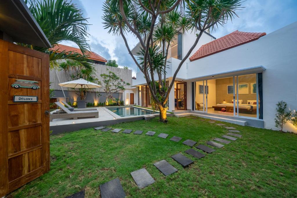 a backyard with a pool and a house at Villa Gemuk in Seminyak