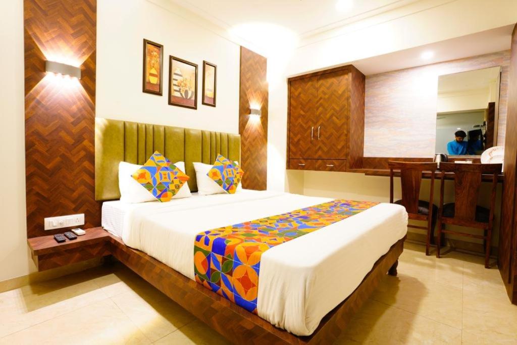 a bedroom with a bed and a desk in a room at Hotel Diamora Residency in Thane
