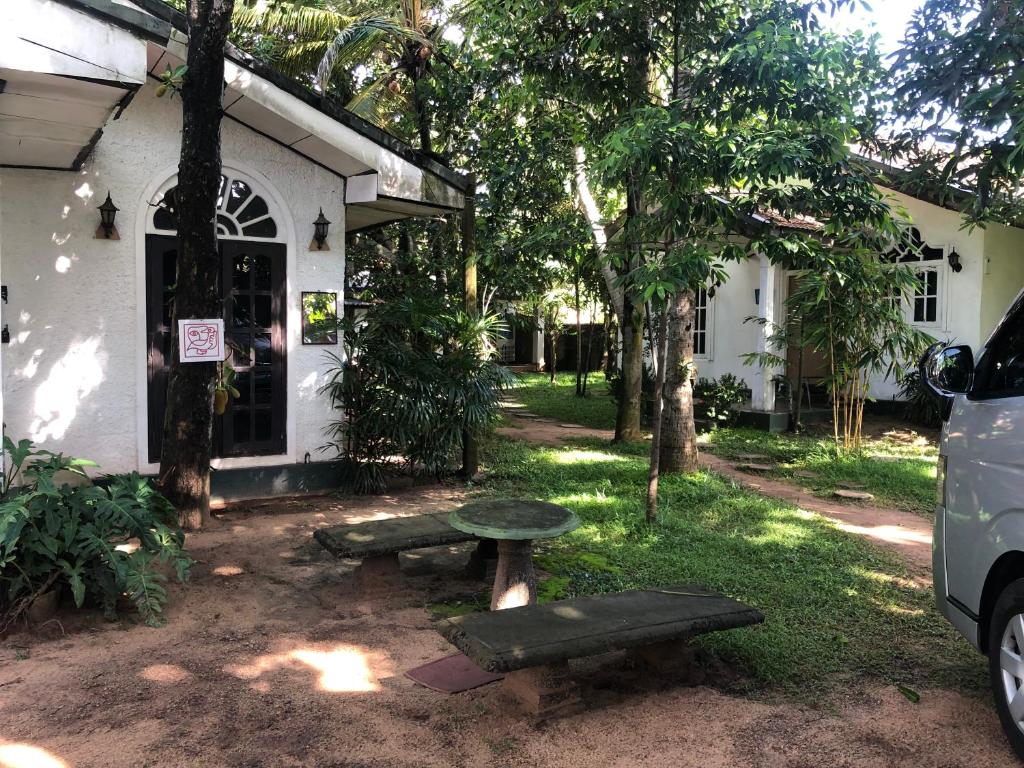 ネゴンボにあるSylvester Villa Hostel Negomboの建物前のピクニックテーブルとベンチ