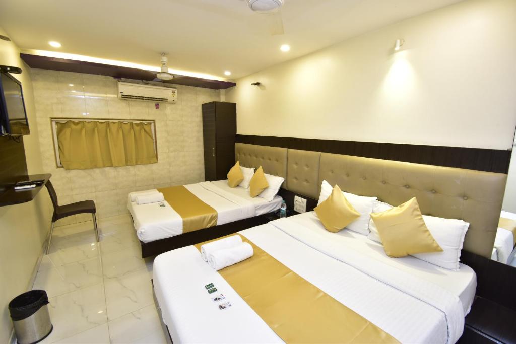 a hotel room with two beds and a tv at Hotel BKC Palace Inn - Jio world convention center and us visa center హోటల్ బి కే సి ప్యాలెస్ ఇన్ in Mumbai
