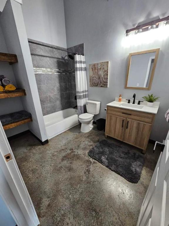 a bathroom with a toilet and a tub and a sink at Canadian river villas in Amarillo