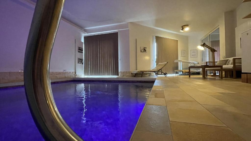 einen Pool mit lila Wasser in einem Zimmer in der Unterkunft Une Nuit Ailleurs in Le Locle
