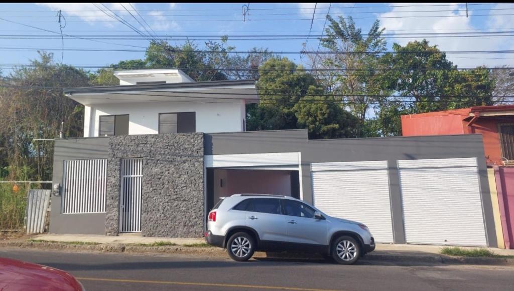 un pequeño coche aparcado frente a una casa en Casa Murillo, en San José