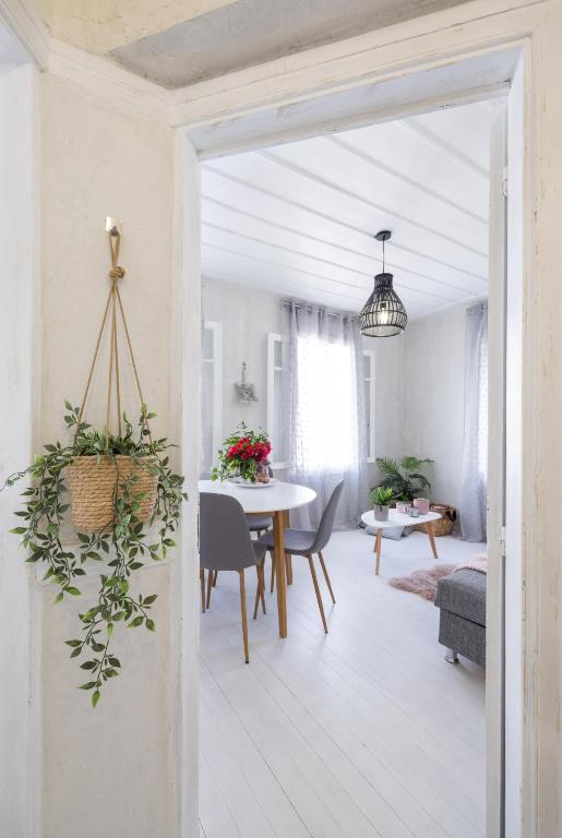 a white living room with a table and chairs at Theros Cottage - garden & sea breeze in Nafplio
