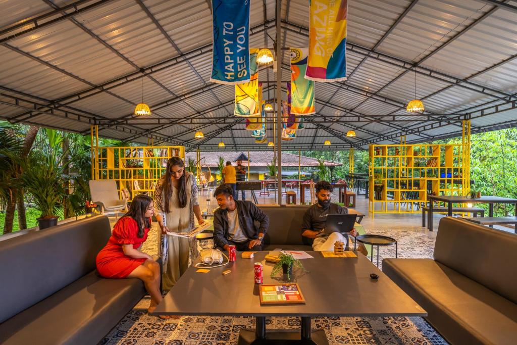 un grupo de personas sentadas alrededor de una mesa en un restaurante en The Hosteller Wayanad en Vythiri