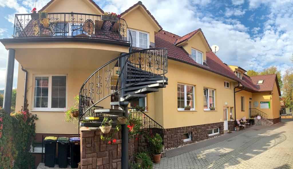 a house with a spiral staircase on the side of it at Penzion Olga Hajasova in Bojnice