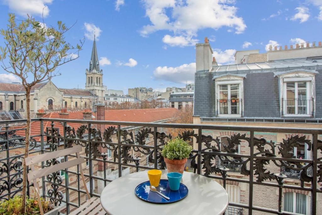 une table sur un balcon avec vue sur une ville dans l'établissement Appartement du Fenoux - Welkeys, à Paris