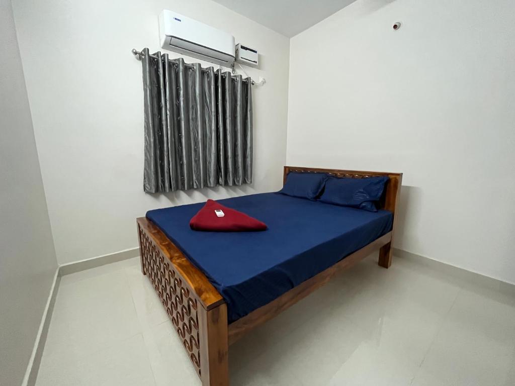 - une chambre avec un lit doté d'un oreiller rouge dans l'établissement CM STAYS & SERVICE APARTMENT, à Chennai