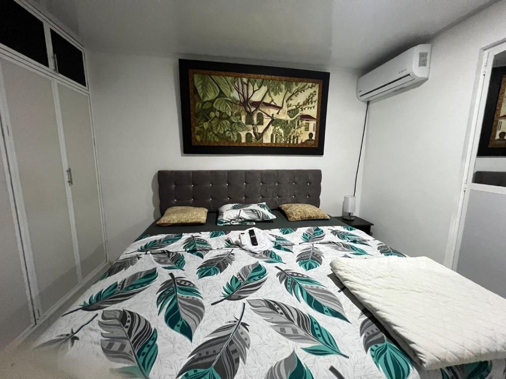a bedroom with a bed with a green and white comforter at Habitacion Donde Anita in Florencia