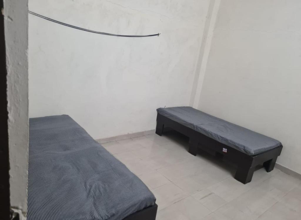 a bed sitting in a room with a bench at Oonesty Home Stay in Ahmedabad