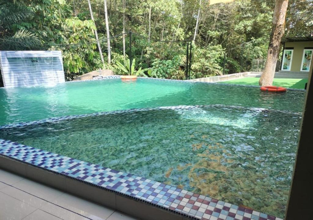 a large swimming pool with green water in a yard at Bentong Wellness Resort Midland 8BR 30PAX By Verano Homestay in Bentong