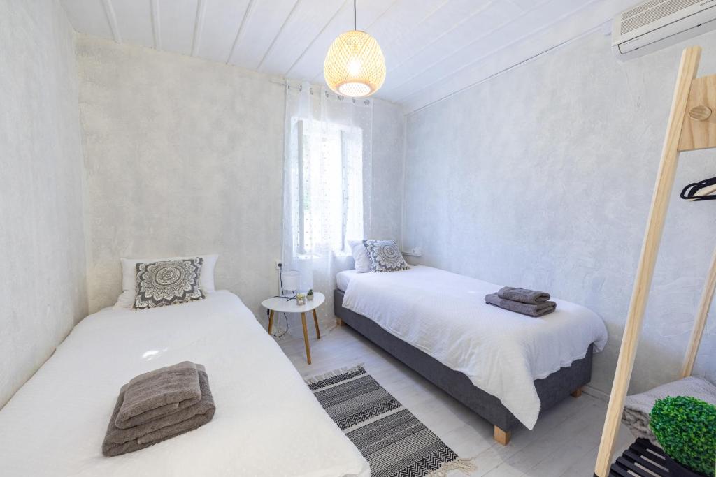 納夫普利翁的住宿－Theros Cottage Nafplio，一间卧室配有两张床和吊灯。