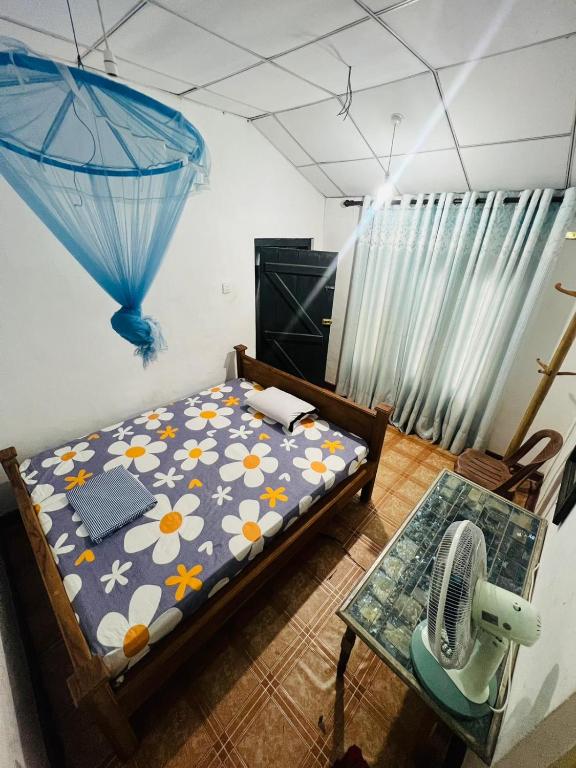 Galoya30 hotel & safari في Hida: غرفة نوم بسرير وطاولة مع مروحة