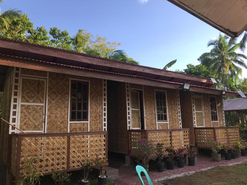 a wooden house with windows and a balcony at Chloe’s Paradise Hostel in Batuan