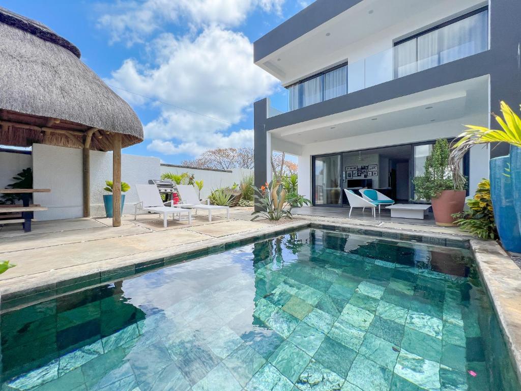 a villa with a swimming pool and a house at Résidence Celestial - Premium 3 bedrooms Villa with volcanic stone Pool in Grand Baie