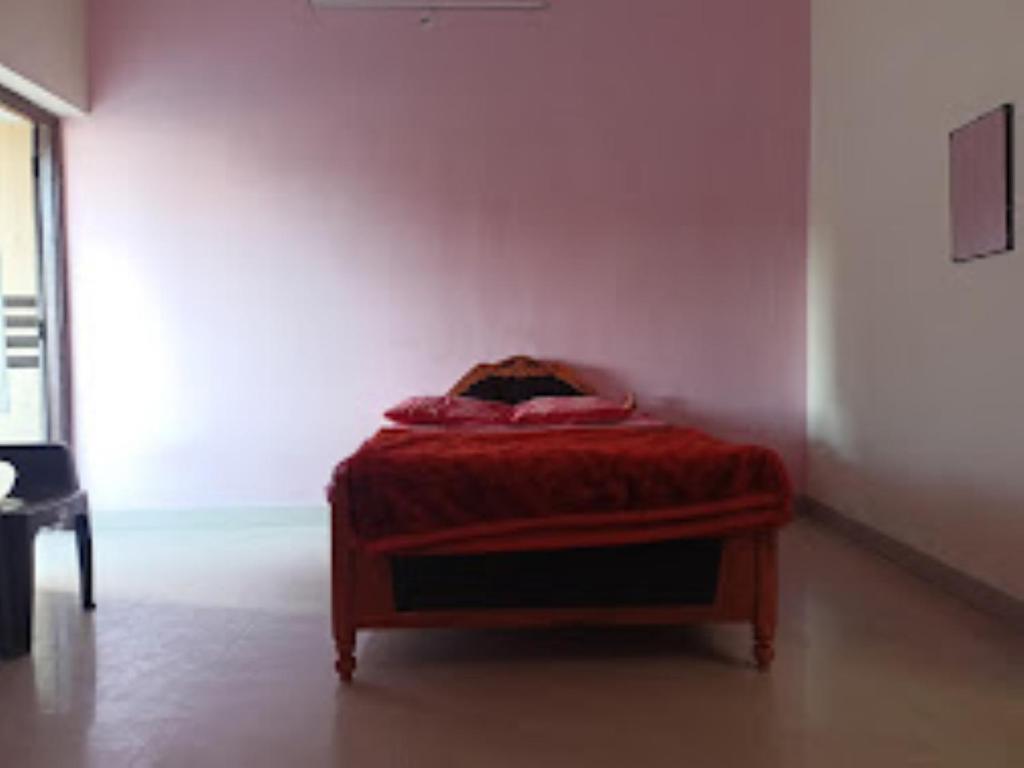 een bed in een kamer met een rode deken erop bij Two Brother's Hotel lodging And Restaurant WARDHA in Wardha
