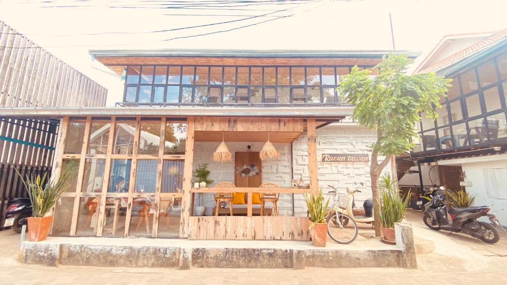 una casa con una mesa y sillas frente a ella en เรือนตะวัน เกาะล้าน RueanTawan Kohlarn en Ko Larn