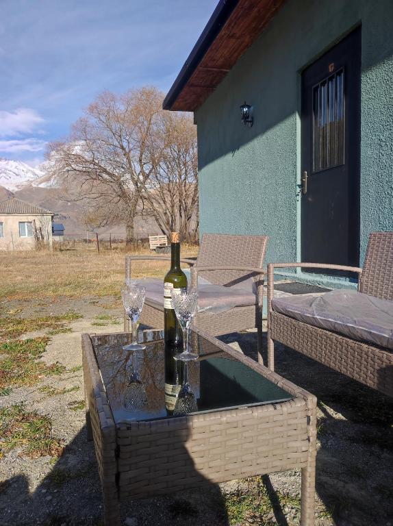 a table with a bottle of wine and two glasses at COZY house მყუდრო სახლი in Kazbegi