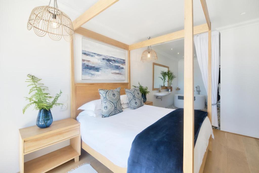 a bedroom with a large bed and a bathroom at Oceans Guest House & Luxurious Apartments in Struisbaai