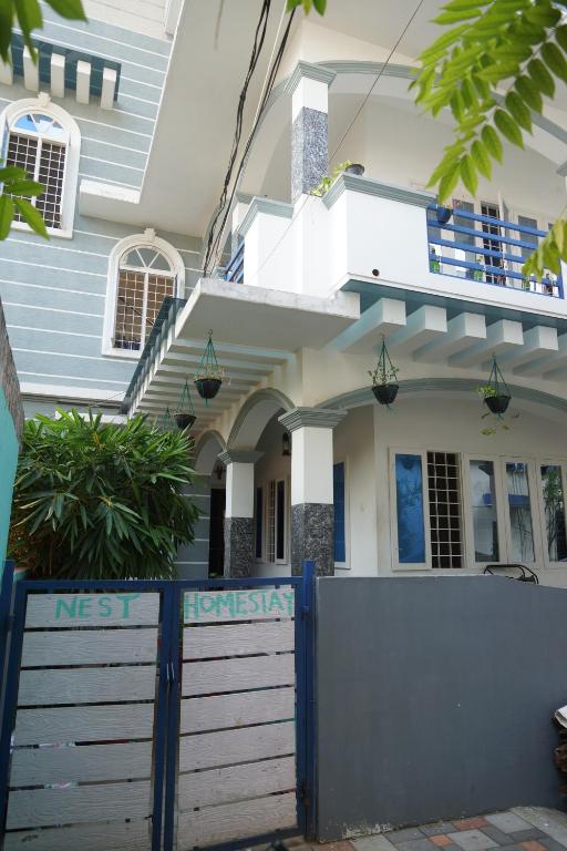 une maison avec une clôture bleue devant elle dans l'établissement Nest, à Cochin