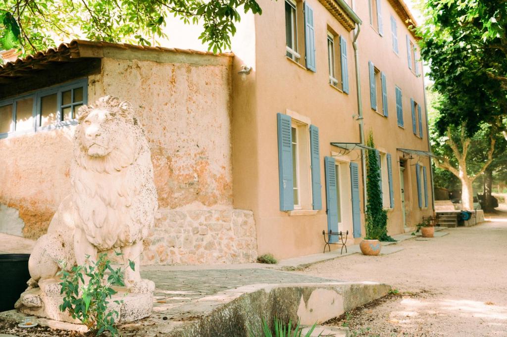 a statue of a lion in front of a building at Gîte dans Bastide Provençale, Piscine & Sauna in Auriol