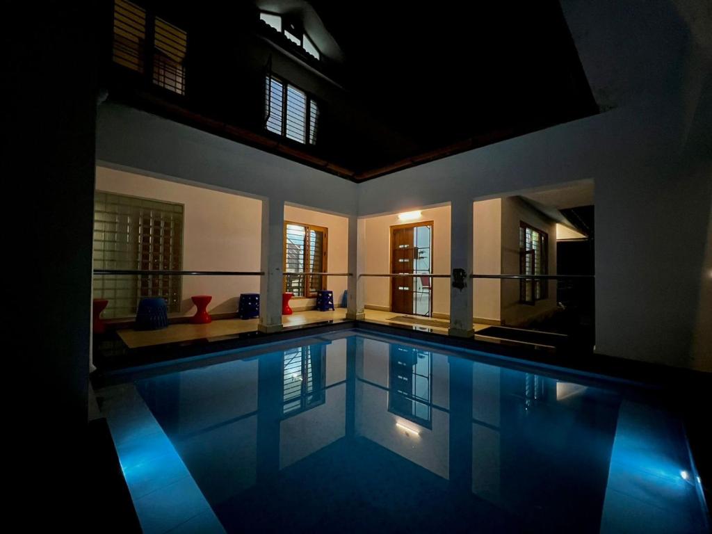una grande piscina in una casa con illuminazione blu di Casita Greenacres Homestay a Vythiri