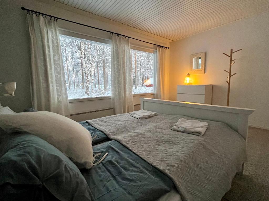 a bedroom with a bed and a large window at Kuurala apartment in Rovaniemi