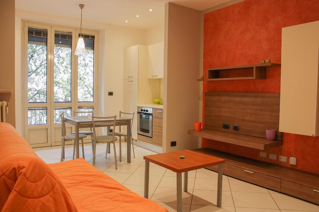 un soggiorno con un divano e un tavolo di Casa Giulia a Cuneo