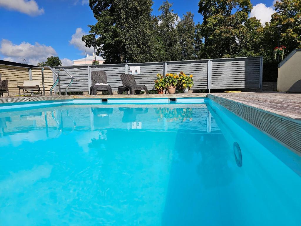 a swimming pool with blue water in a yard at "Indian Summer" Apartment in Viljandi