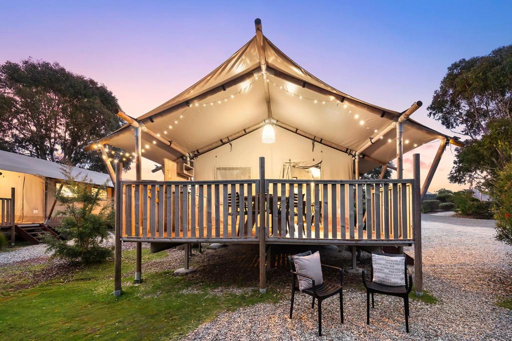 une maison avec une terrasse couverte dotée de chaises et de lumières dans l'établissement Scamander Sanctuary Holiday Park, à Scamander