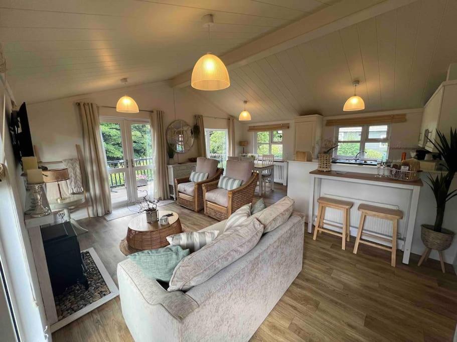 a living room with a couch and a kitchen at Waterside Lodge, Weybourne, Holt in Weybourne