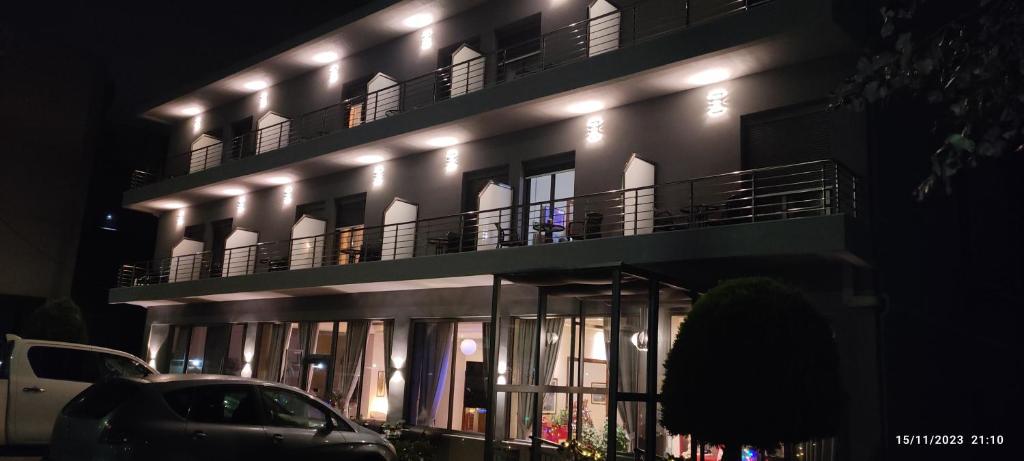 un'auto parcheggiata di fronte a un edificio di notte di Hili Hotel a Alexandroupoli